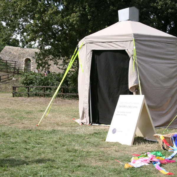 An image of the nomadica camera obscura in action. A small tent is erected in a field.