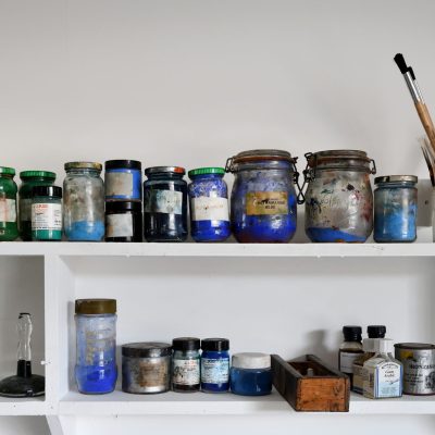 An image of shelving with various printing inks in jars on them in the Print Workshop at Gainsborough's House.