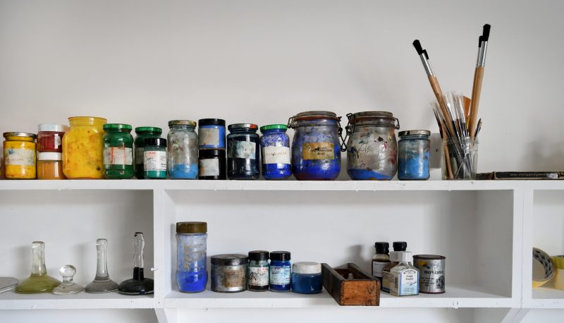 An image of shelving with various printing inks in jars on them in the Print Workshop at Gainsborough's House.