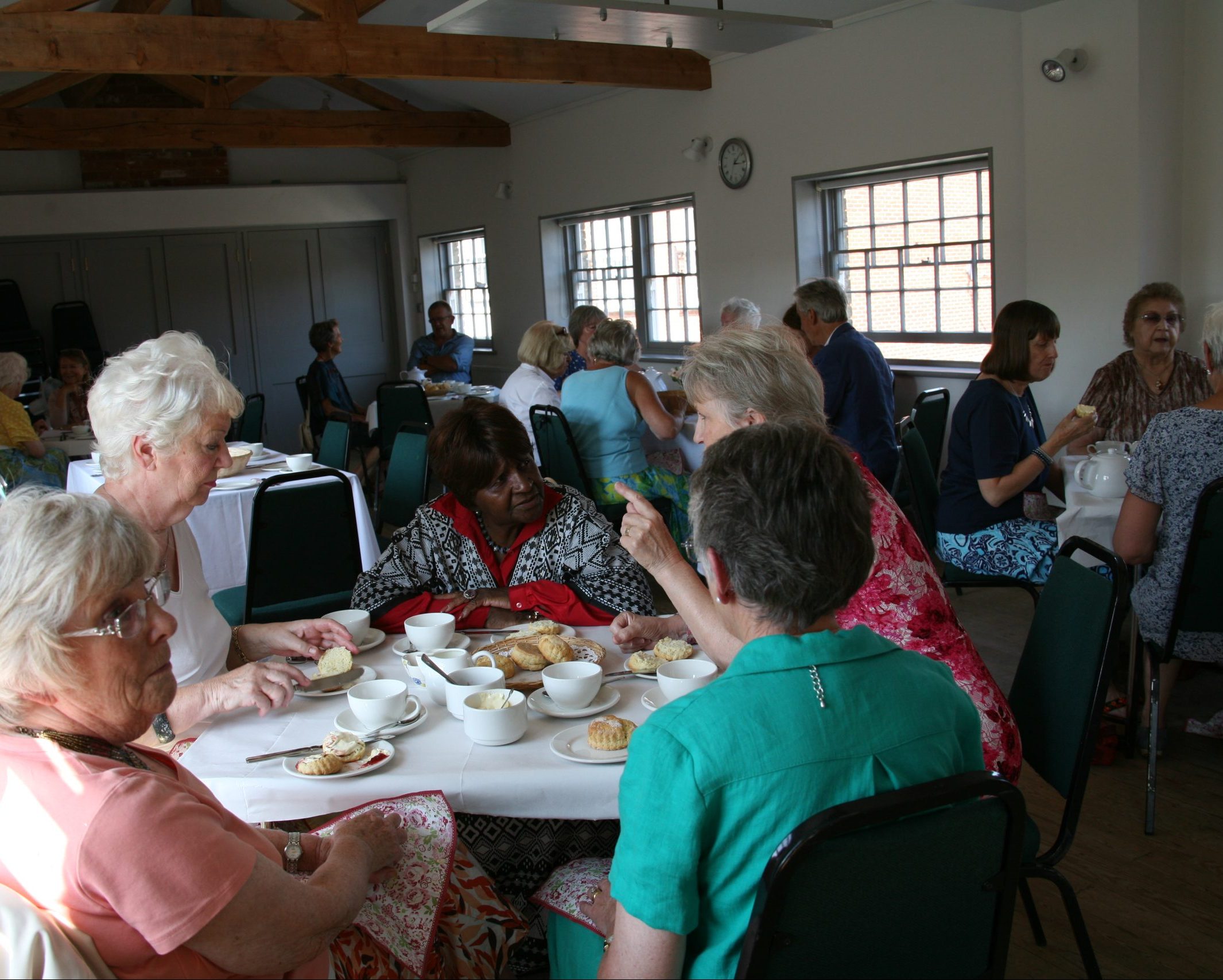 An image of a large group of people enjoying afternoon tea in the Hills Room for hire at Gainsborough's House.