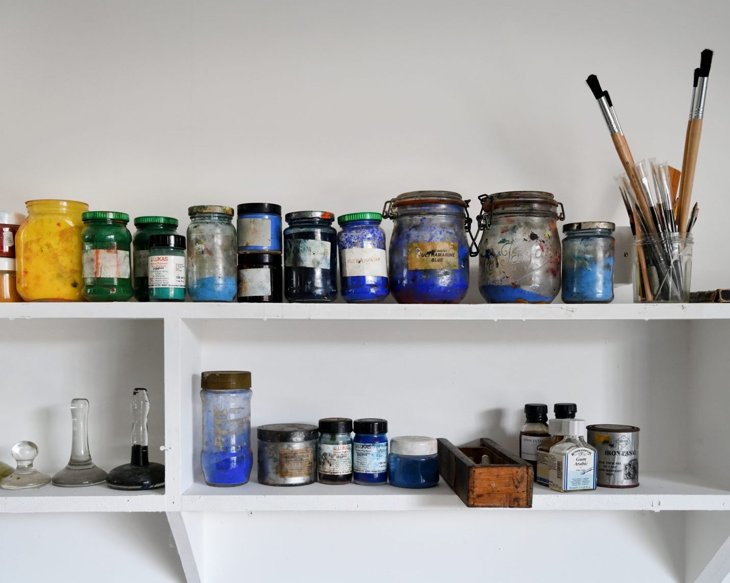 An image of printing ink pots on a white shelf.