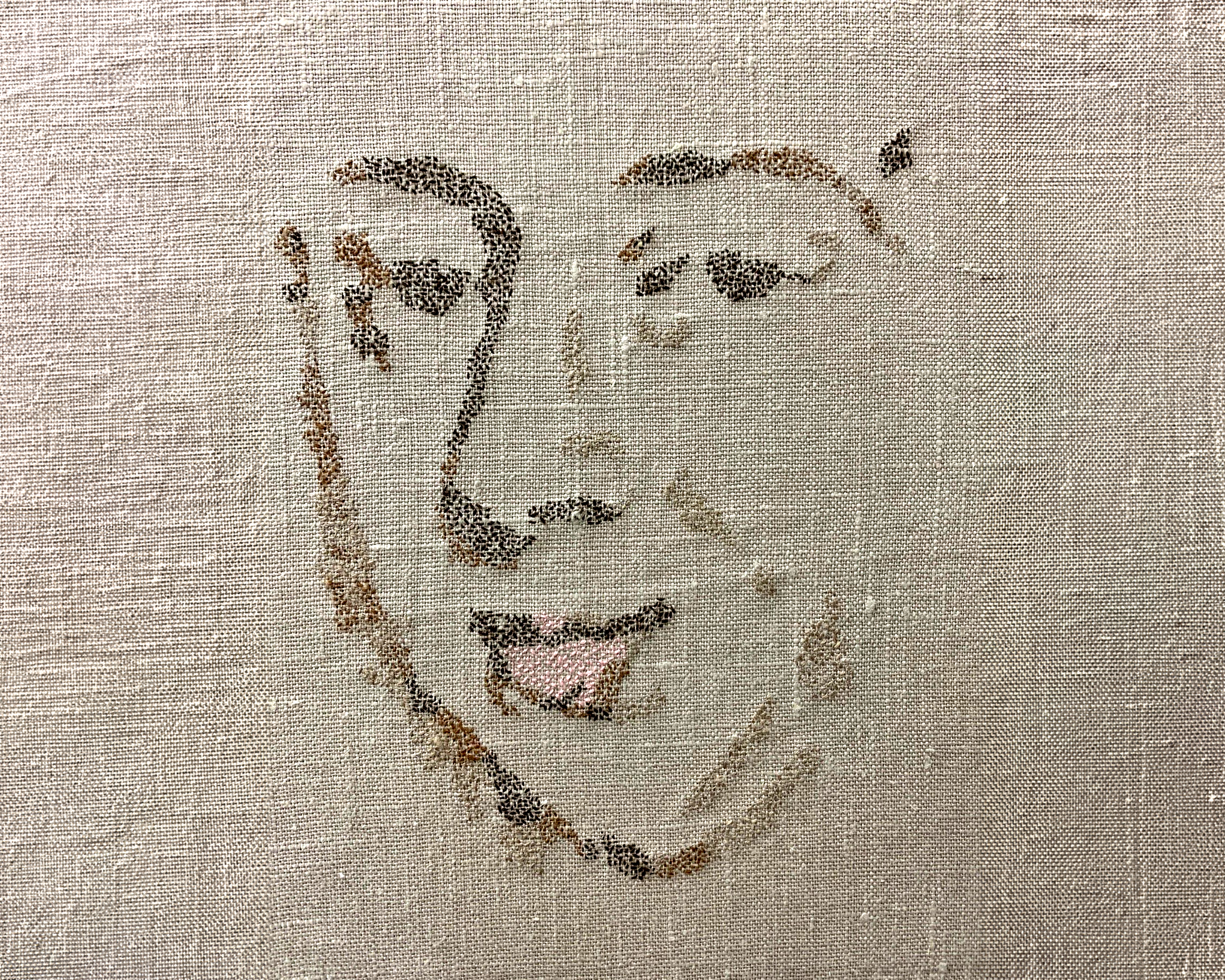 An image of a stitched portrait on canvas material.