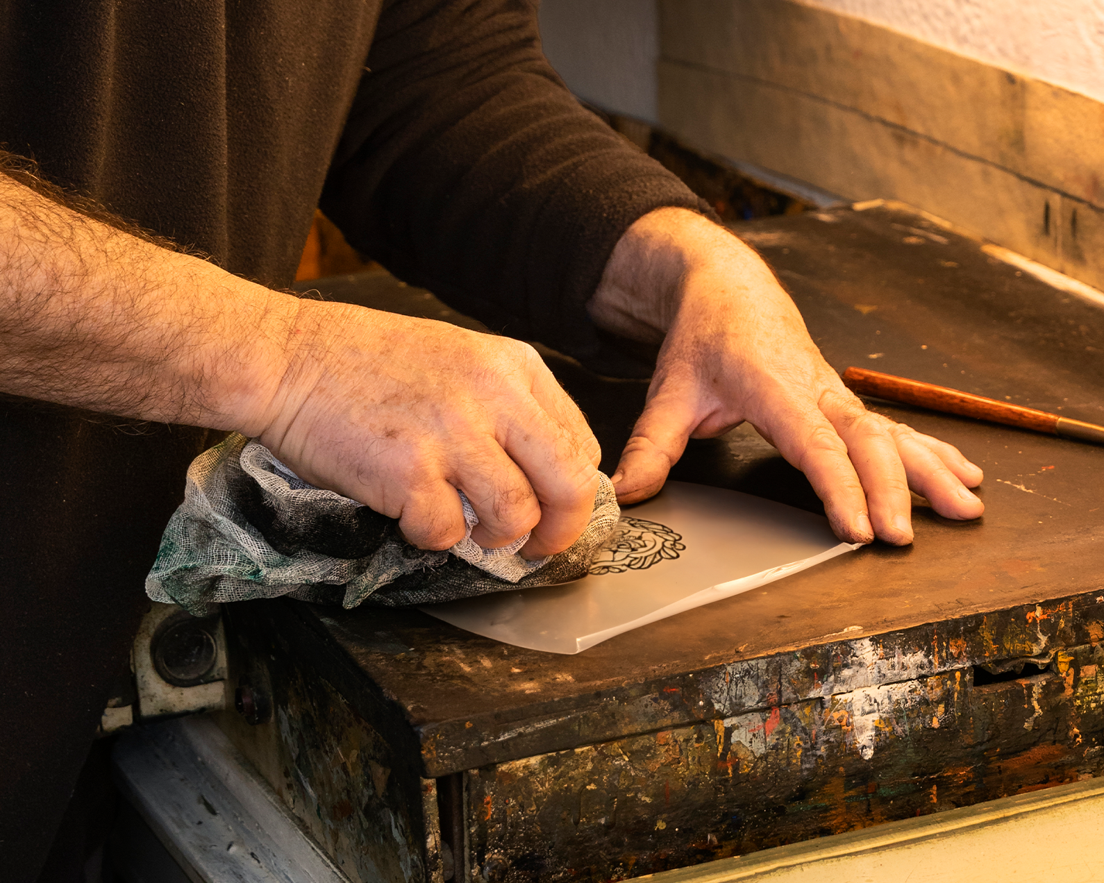An image of a person inking up an acetate engraved plate.